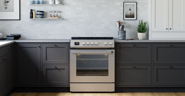 A kitchen with dark cabinets, a cream stove, white tile backsplash, open shelves, framed art, and wood flooring.